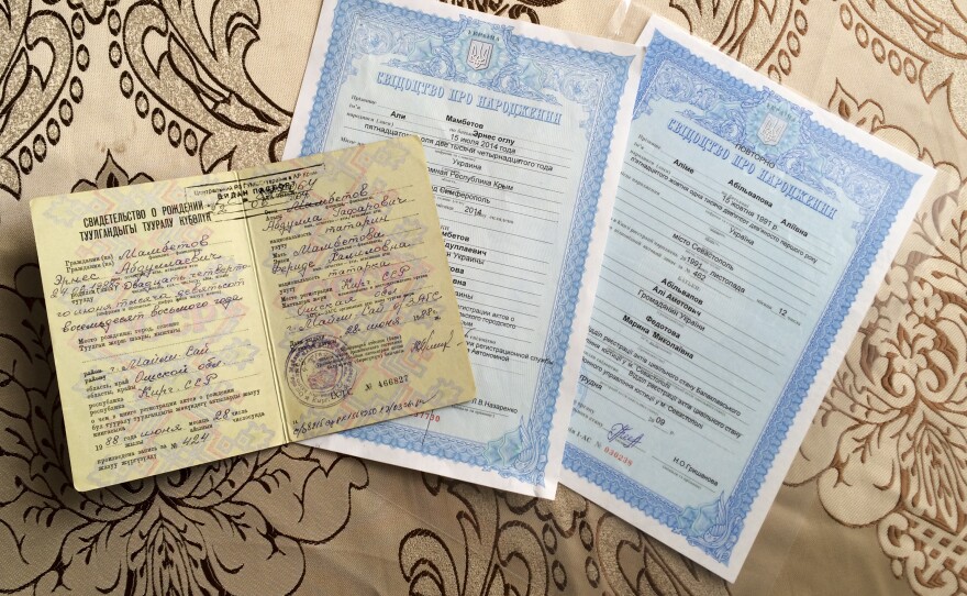 The top document is Ernes Ayserezli's Soviet birth certificate. His wife, born after the Soviet Union collapsed, has a Ukrainian one – the very same Ukrainian document that the couple wanted so badly for their infant son, Ali. They made it just in time, before the hospital began printing Russian ones.