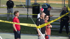 Members of the Republican Congressional softball team stand behind police tape in Alexandria, Va., Wednesday, June 14, 2017, after a multiple shooting involving House Majority Whip Steve Scalise of La. during a congressional baseball practice. (Cliff Owen/AP)