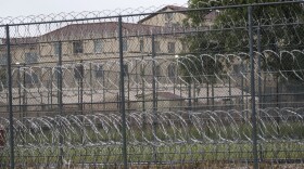 Wire fences near buildings of the Federal Medical Center prison in Fort Worth, Texas, Saturday, May 16, 2020. Hundreds of inmates inside the facility have tested positive for COVID-19. (LM Otero/AP)