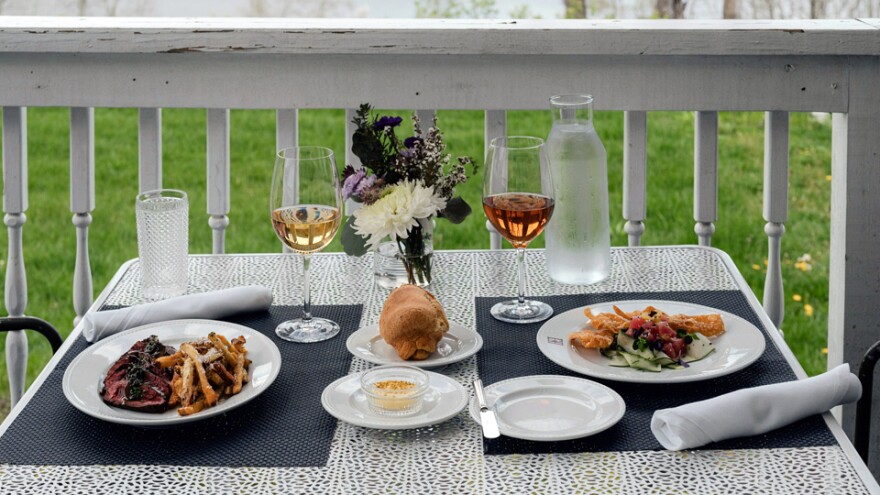 a table set for dinner. two pots, different dishes, and different glasses of wine