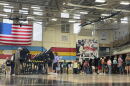 People stand a voting booths in a school gym.