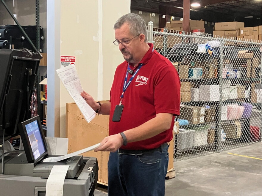 Scott County elections manager James Martin feeds test ballots into a voting tabulation machine at a warehouse in Eldridge, Thursday, Oct. 8, 2026.