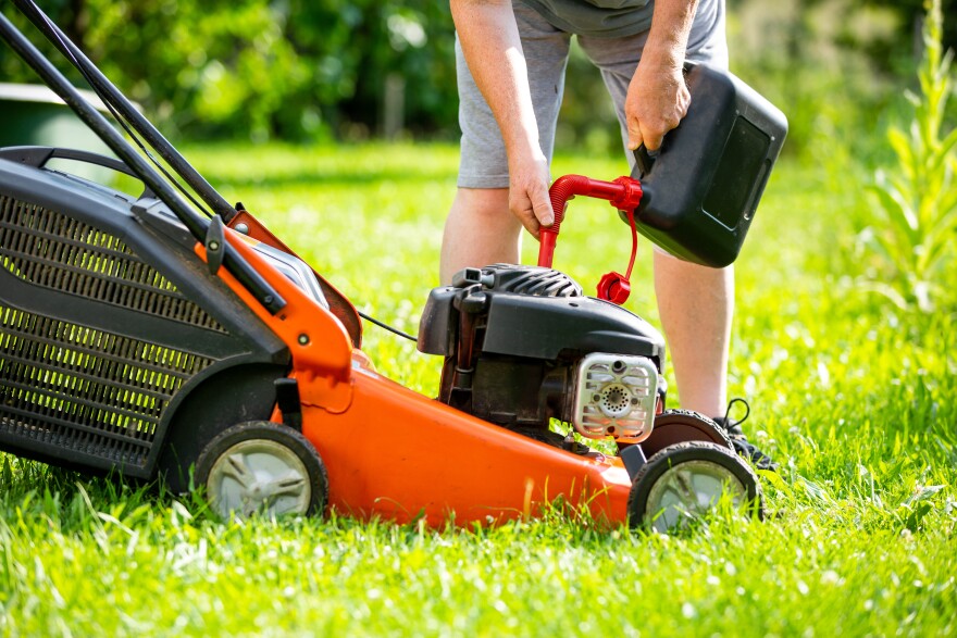This stock images depicts a person putting gas in a lawn mower.