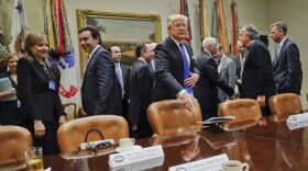 President Donald Trump tosses his folder on the table before the start of a meeting with automobile leaders in the Roosevelt Room of the White House in Washington, Tuesday, Jan. 24, 2017. (Pablo Martinez Monsivais/AP)