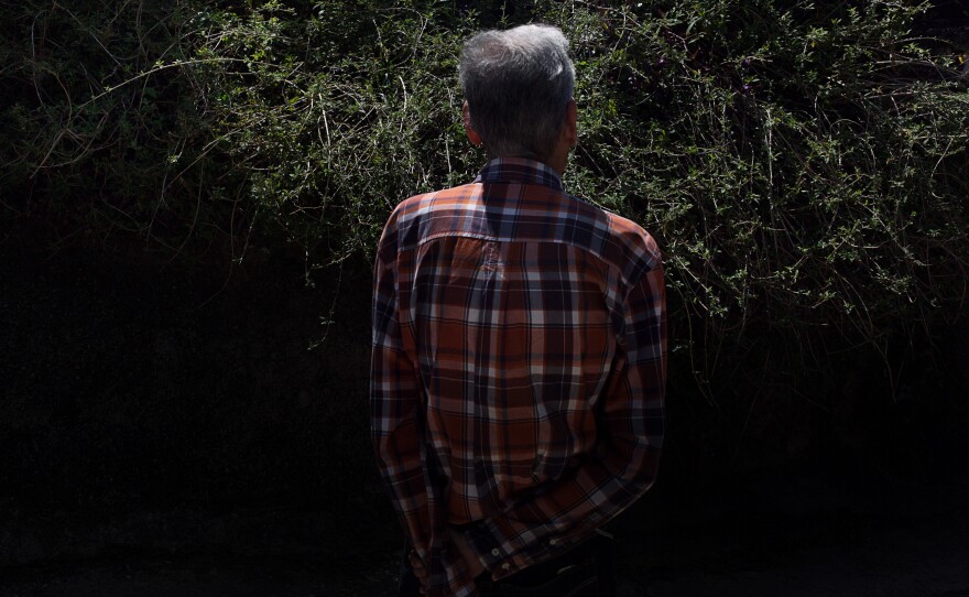 A resident stands in front of a Melissa tree. In folk medicine, tea made with the leaves is believed to have healing properties.