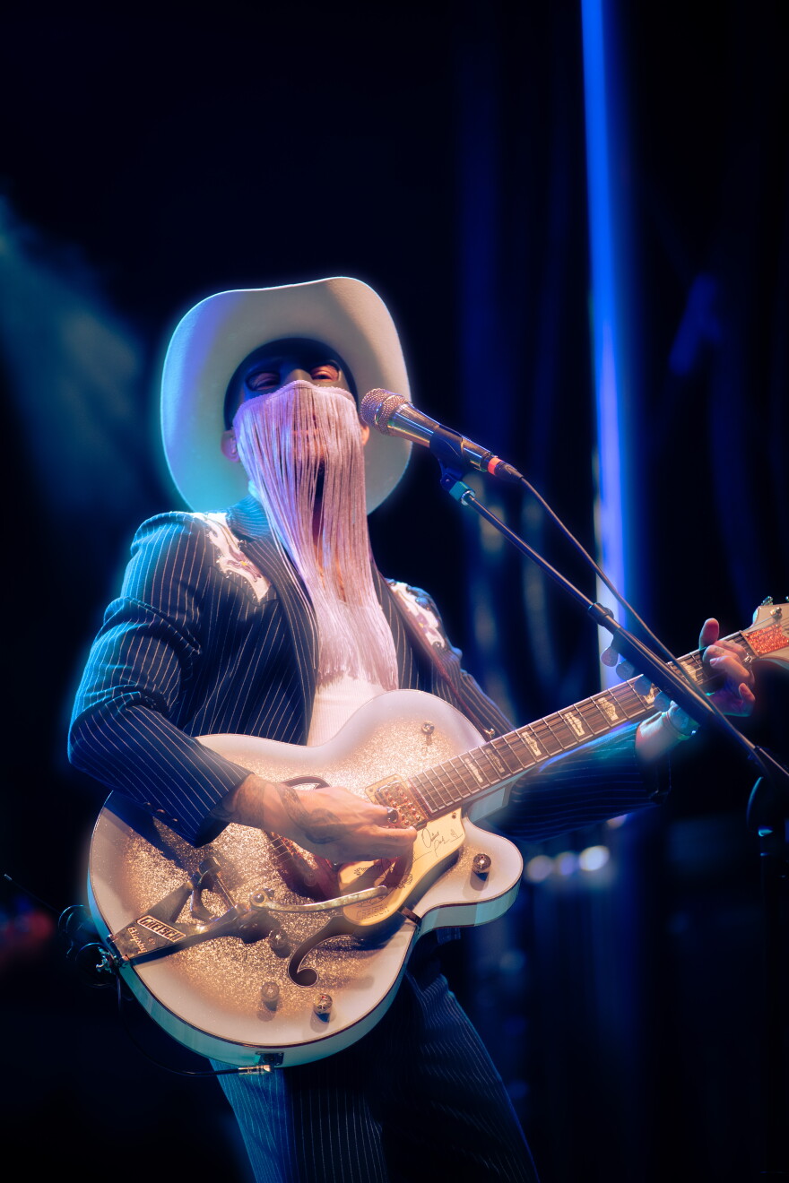 a man wearing a mask playing guitar 