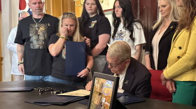 Gov. Mike DeWine signs an order recognizing National Childhood Cancer Awareness Month, with the Zurlinden family to his left.