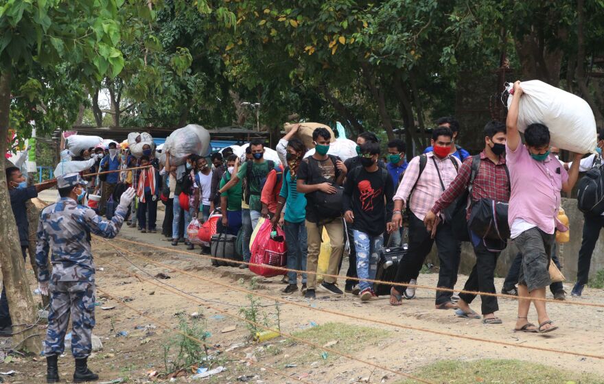 Nepali migrant workers return to Nepal at the India-Nepal border in Dhangadi, some 400 miles west of Kathmandu. Returning workers are often stigmatized because of fears they could be bringing the coronavirus pathogen from hard-hit India.