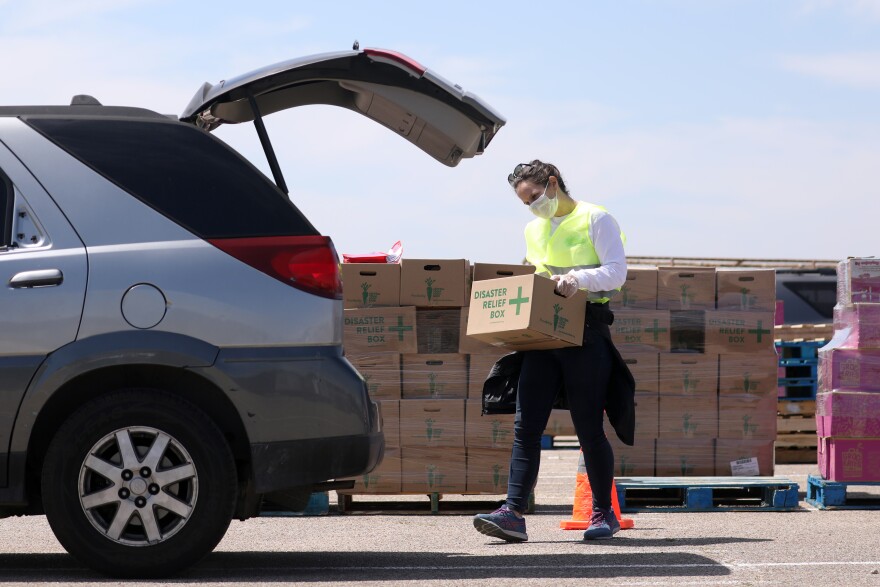 A volunteer puts a box of food in a person's car during a Central Texas Food Bank food distribution in April.