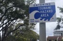 FILE - A sign indicates the border of the tsunami evacuation zone on Kalākaua Avenue on Oʻahu.