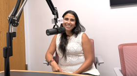 Dr. Javiera Monardez Popelka sitting behind a microphone in the WGLT studios.