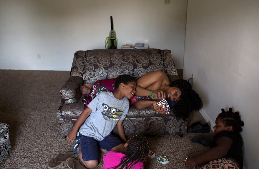 McClellan plays the card game UNO with her kids and their friend in the Southeast Washington, D.C., apartment the family moved into in March.