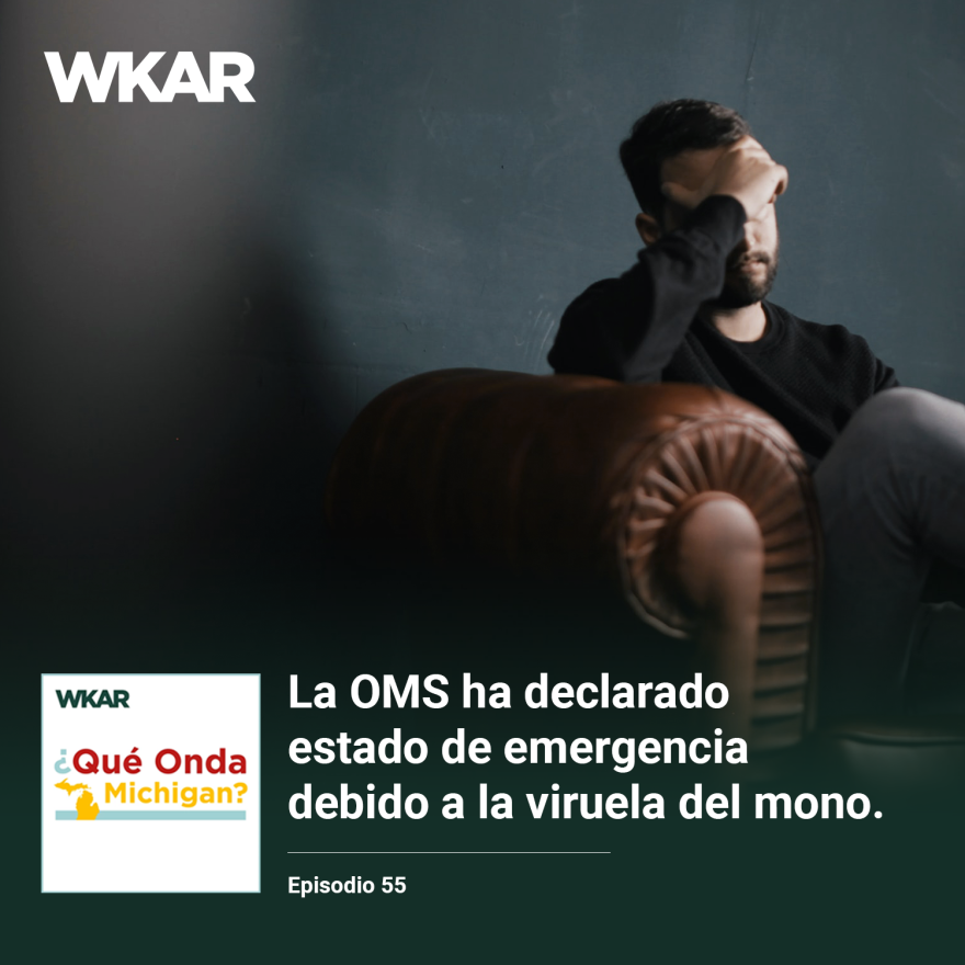 En la imagen se puede observar a un hombre sentado en un sillon color cafe. Se esta tocando la frente con la cabeza semi-abajo. En el lado inferior de la imagen esta el logo de Que Onda Michigan sobre un fondo blanco. En la parte derecha las siguientes palabras estan escritas: "La OMS ha declarado estado de emergencia debido a la viruela del mono "  y "Episodio 55". 