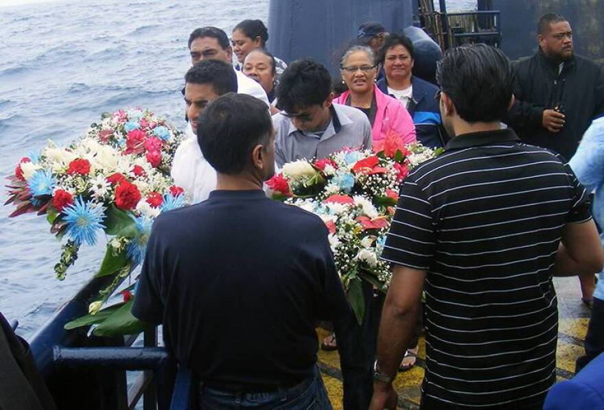 Two members of the Suleman family prepare to lay the wreaths during a memorial service honoring Haris Suleman who died and his father, Babar Suleman, who is missing after their plane crashed during an attempt to circumnavigate the world.
