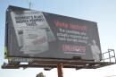 A billboard shown on Thursday, Oct. 8, 2026 stands on the northbound side off Business 97 in Bend, Ore. It depicts a fake newspaper and headlines alongside a real image of Deschutes County Commissioner candidate Rob Imhoff. The billboard discloses using AI.