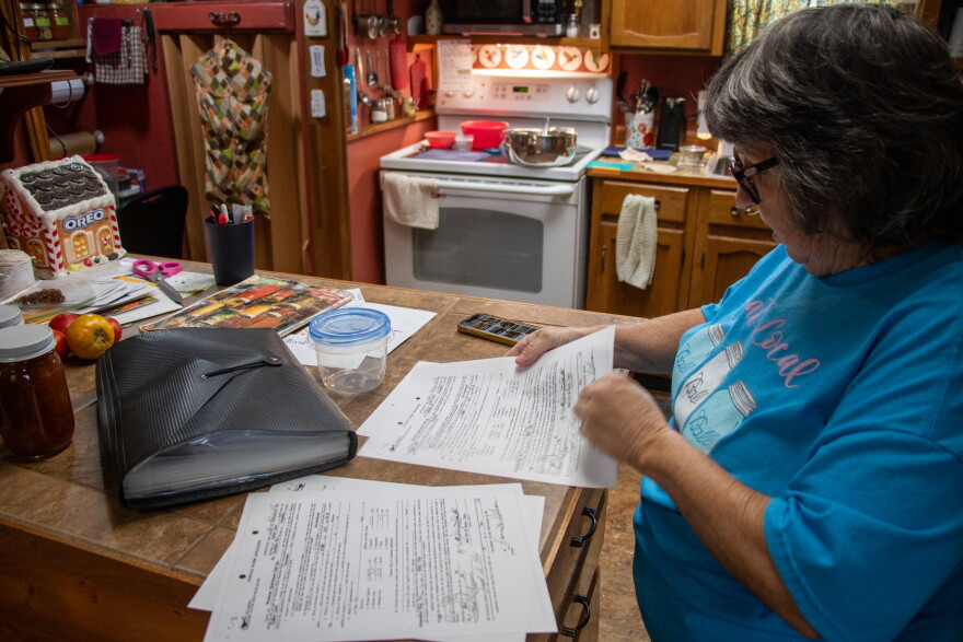 In her kitchen, ongtime Cedar Lake resident Tammy Cramer looks over copies of the Western Sportsman Club's water rights application from 1960.
