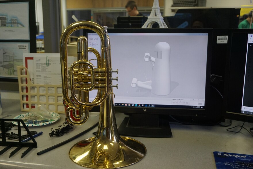 A mellophone in front of a picture of a 3-D printer schematic for a possible support system. Taken at Rolla RTI 02-28-20