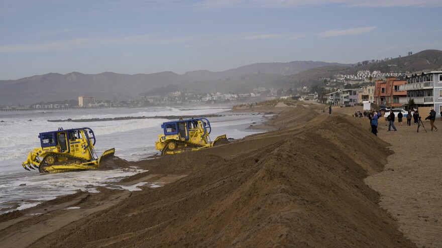 A sand berm is bulldozed to prevent high surf from impacting beachfront properties on Friday in Ventura, Calif.