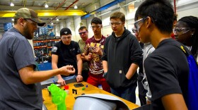 Jeremey Rorie shows Penn High School students what he does for work at B&B Molders in Mishawaka.