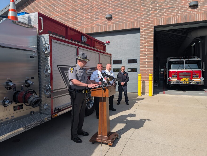 Lt. Christian Perrin, Ohio State Highway Patrol Wooster Post Commander, speaks behind a podium in front of a firetruck. 