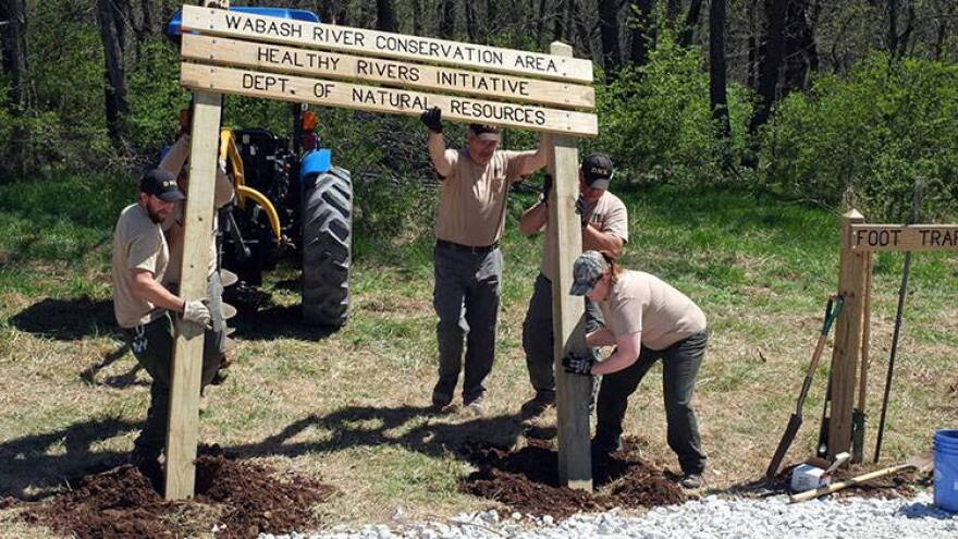 Indiana Division of Fish and Wildlife staff work to install a sign at the Wabash River Conservation Area.