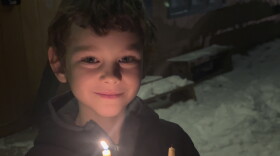 Roger Parks, an early grades student at the Anchorage Waldorf School, holds his apple with a beeswax candle inside.