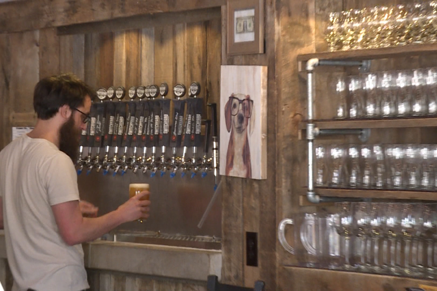 A bartender serves beer at Switchyard Brewing in Bloomington.