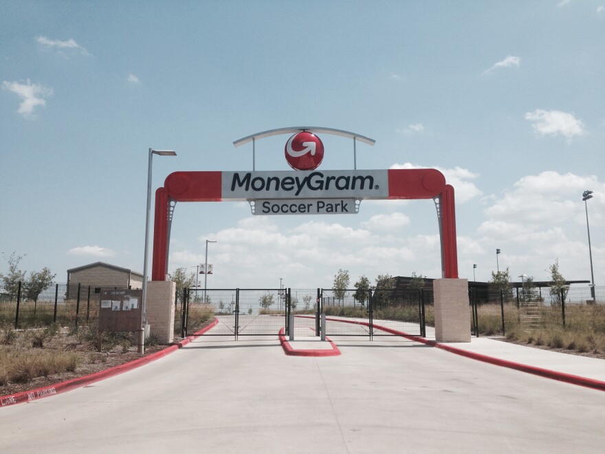 photo of the entrance of a soccer field with large black and white letters on the sign that say MoneyGram Soccer Park