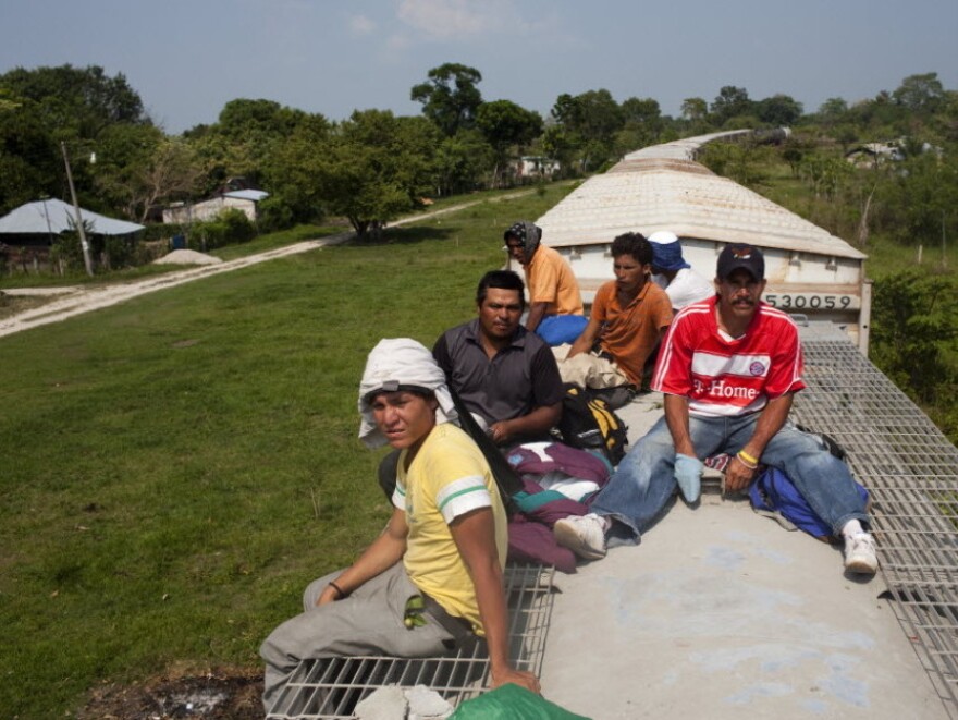 Migrants ride on top of a freight train that left from Tenosique, Tabasco.