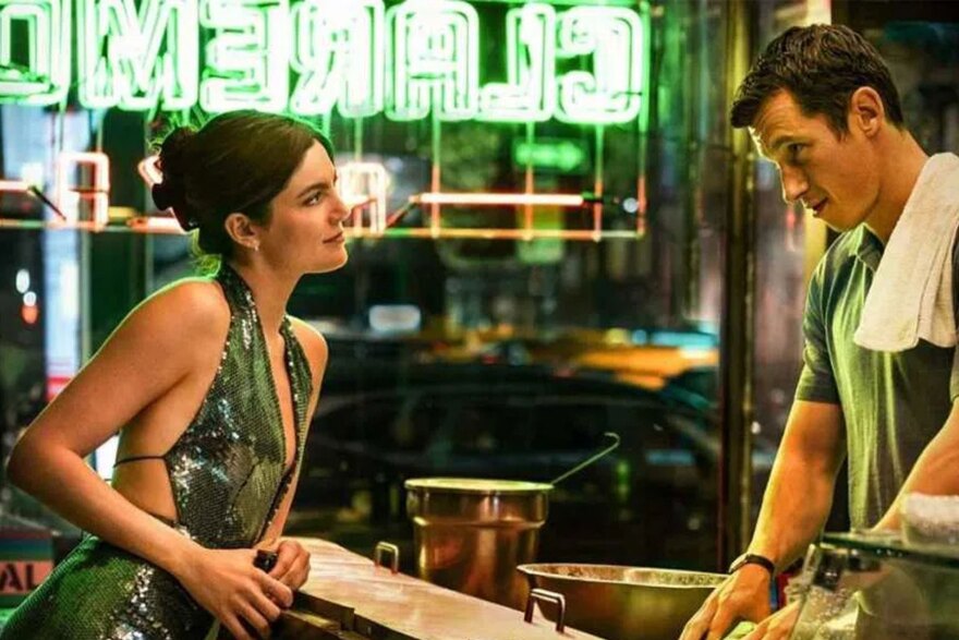 Man and woman gaze at each other across the bar