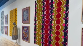 Framed artwork and textiles on a white wall