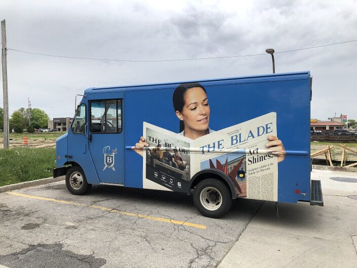 A delivery van for the Toledo Blade, a nearly 200-year-old paper in Northwest Ohio, is parked in a lot.