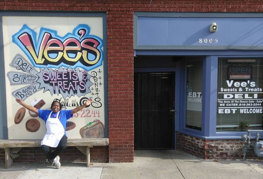 A smiling Vee Toney sits outside Vee's Sweets & Treats.