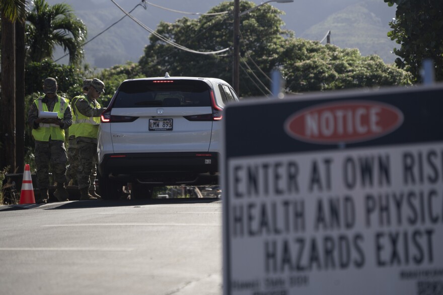 The Hawaii National Guard checks on a car passing the checkpoint on Kaniau Street on Monday, Sept. 25, 2023, in Lahaina, Hawaii.