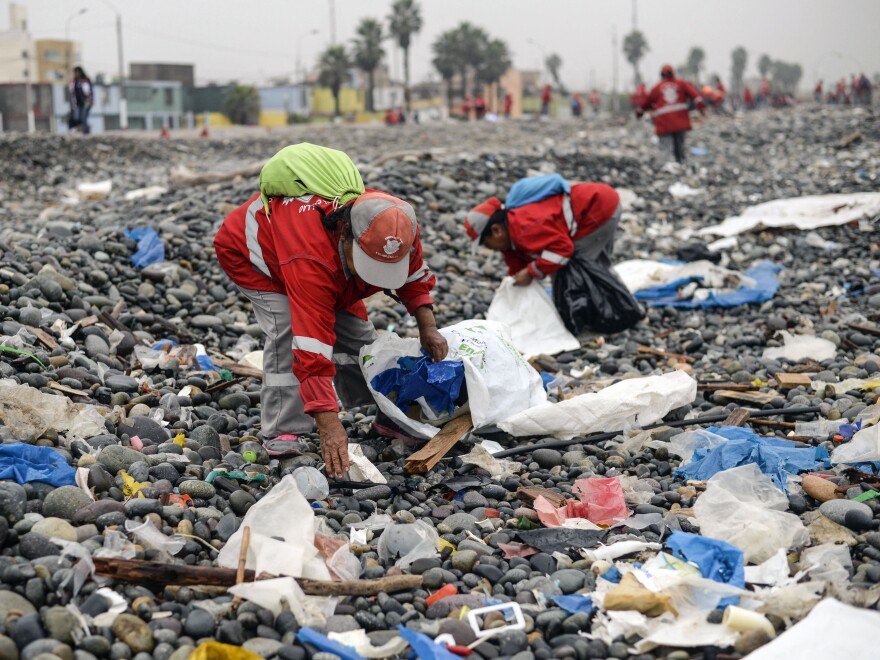 Volunteers clean up plastic waste on a beach in Peru.