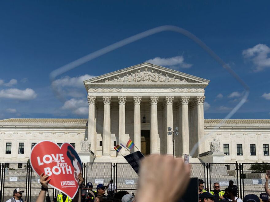 Protesters holding signs outside the US Capitol building. 