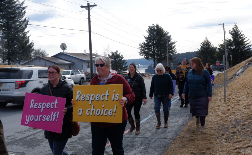 Some marchers carried standard signs that were provided by KWRCC and event organizers during the Choose Respect March on April 15.