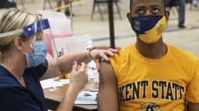 A Kent state student looks away as he gets the vaccine.