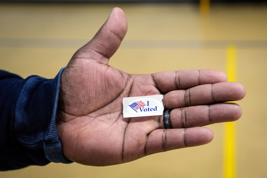 Sasha Dix holds his, "I voted," sticker after voting at T.C. Roberson High School on Election Day, Nov. 5, 2024, in Asheville, N.C.