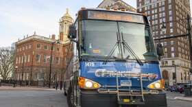 A destination sign over a bus' windshield announces the resumption of fares as it makes its way off Main Street in downtown Hartford.