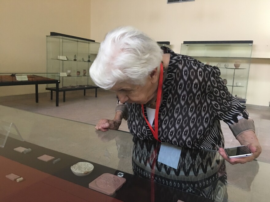 Gailani peers at ancient cylinder seals displayed at the national museum. She curated the original exhibit at the opening of the museum more than 50 years ago.
