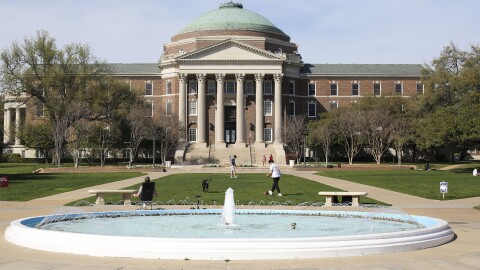 Students play football on the lawn in front of Dallas Hall at SMU.
