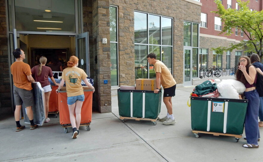 A move-in queue waits outside to enter the dorm