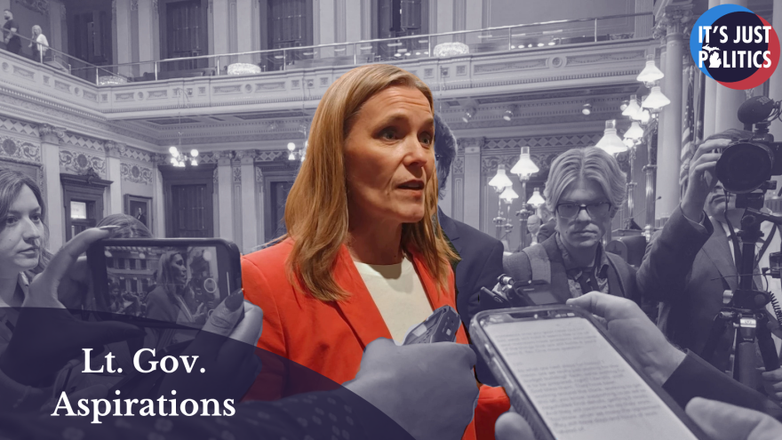 A photo of Winnie Brinks in front of a monochromatic background. In the bottom left corner is a semitransparent semi-circle with the words "Lt. Gov. Aspirations." In the top right corner is the It's Just Politics logo.