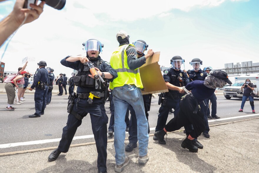 Austin Police officers take at least one protester into custody on Interstate 35 Saturday afternoon.