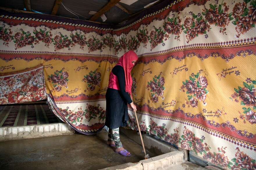 After lunch, Fatmeh cleans the tent where she lives with her family. Her new life, she says, is "work, work, work."