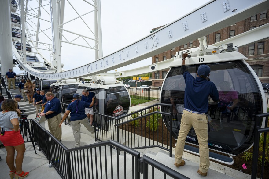 Attendants help riders board the St. Louis Wheel during a media preview event on Sept. 24, 2019. The attraction opens to the public September 20.