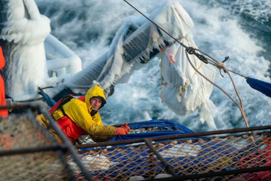 Crewman Jerret Kummer removes a tarp from a stack of crab pots aboard the Pinnacle on Jan. 18 in the Bering Sea southwest of St. Matthew Island. The tarp, which was brand new at the beginning of the voyage three days prior, keeps freezing spray from forming ice within the stack of crab pots. Ice buildup can add significant weight to a boat, changing its stability and increasing the risk of capsizing.