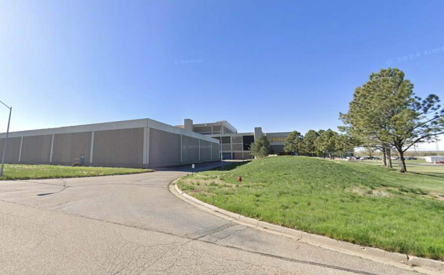 The exterior of a large warehouse looking building with brown walls.