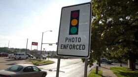 Several red light cameras monitor drivers at urban intersections in Austin, including signs and camera towers at 11th Street and Interstate 35. The cameras are controversial because drivers say they result in more rear-end collisions while police say they cut down on red light violations.